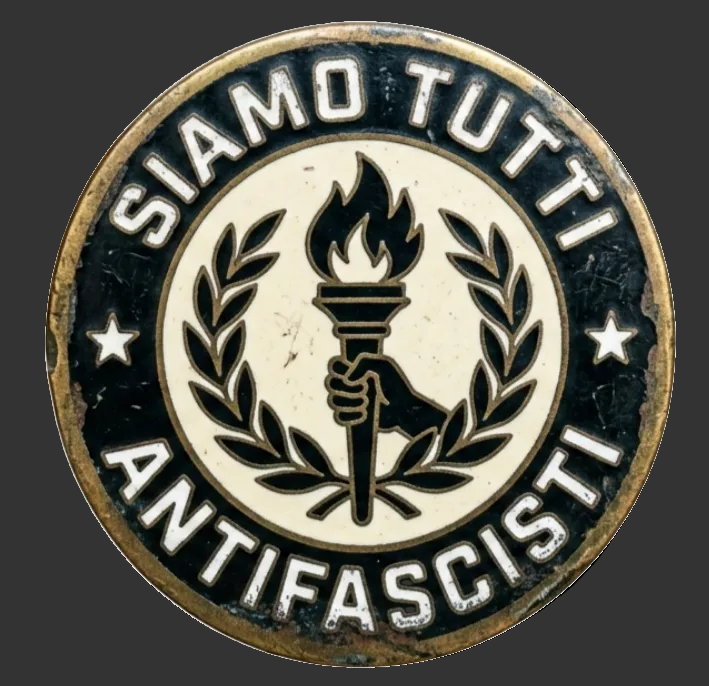 Rundes Emblem mit einer stilisierten Hand, die eine brennende Fackel hält, umgeben von einem Lorbeerkranz und dem Schriftzug „Siamo Tutti Antifascisti“.