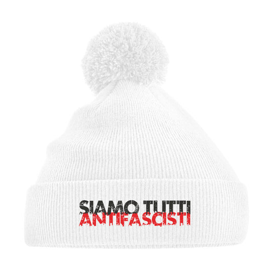 Weiße Strickmütze mit Bommel und dem Aufdruck „Siamo tutti antifascisti“ in Schwarz-Rot – antifaschistisches Winteraccessoire