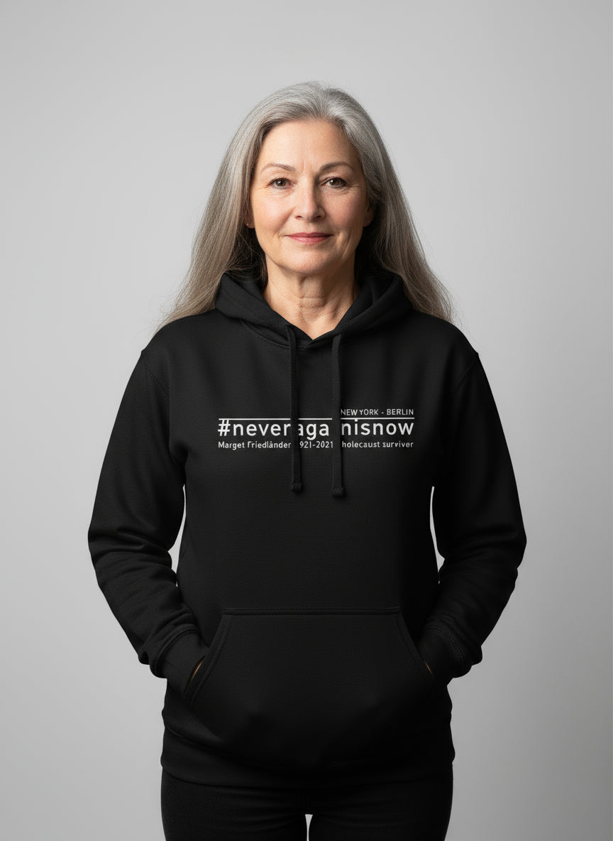 Frau trägt schwarzen Hoodie mit #neveragainisnow und Margot Friedländer Nennung.