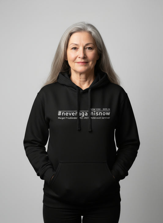 Frau trägt schwarzen Hoodie mit #neveragainisnow und Margot Friedländer Nennung.