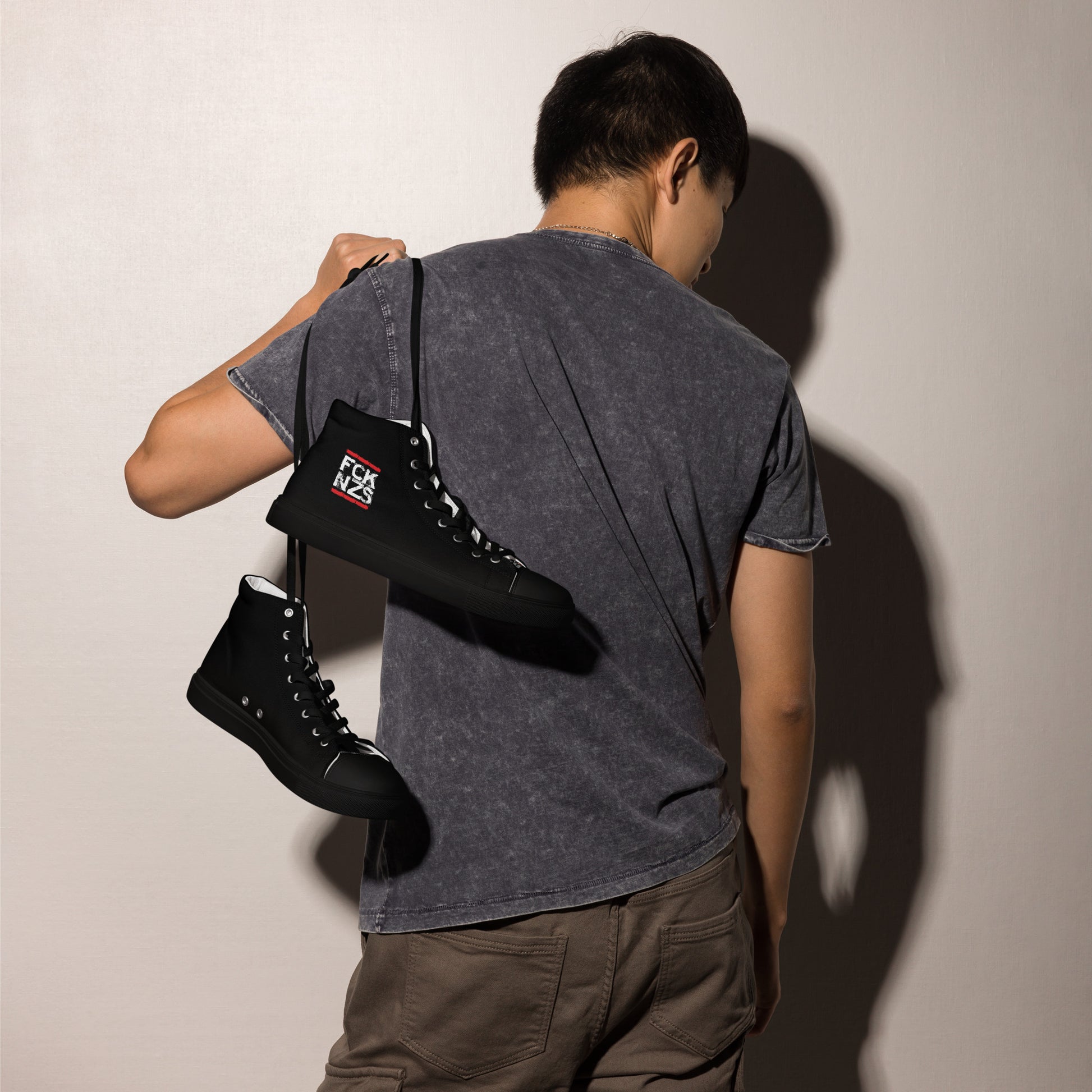 „Schwarze Herren‑Canvas‑Schuhe mit FCK NZS Logo.“